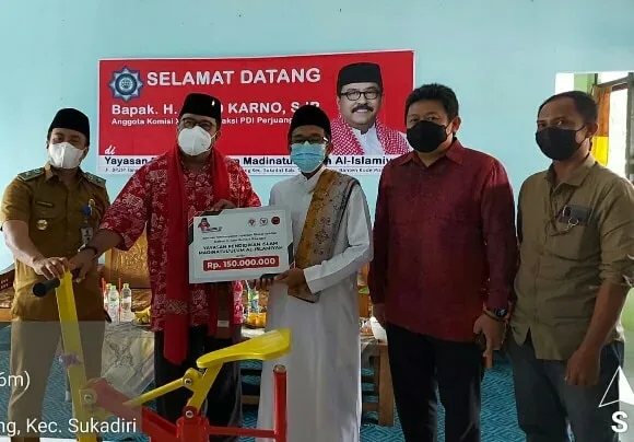 Anggota DPR RI Fraksi PDI Perjuangan Rano Karno Didampingi Ketua DPC PDI Perjuangan Kabupaten Tangerang Irvansyah saat menyalurkan bantuan ke Ketua Yayasan Cahaya Pesisir Utara pengelola SMK Garuda Muhammad Yusuf.