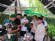 Kepala Desa (Kades) Wanakarta Tumpang Sugian saat menyerahkan baju seragam TNI kepada tim Intel Kodim 0510/Trs di Taman Baso Aci Akang Perum Islamic Kecamatan Kelapa Dua Kabupaten Tangerang, Jum'at (11/03/2022).