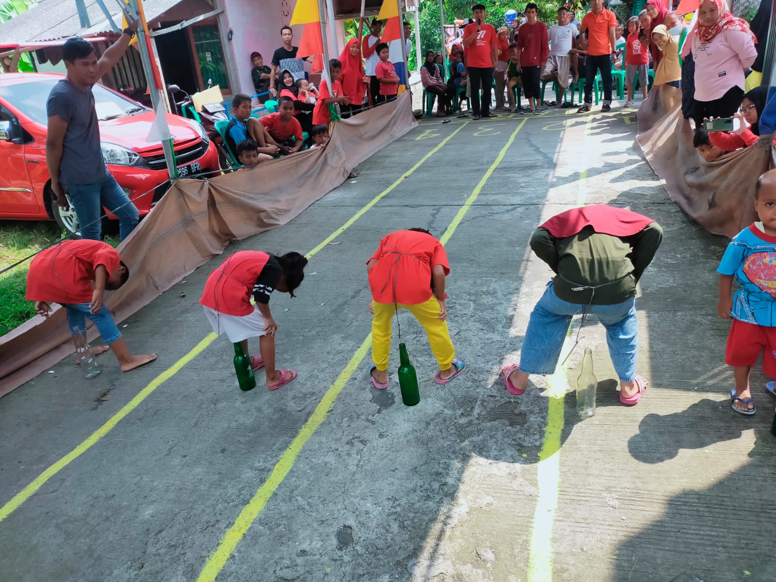 Anak-anak saat mengikuti lomba memasukan paku ke dalam botol.