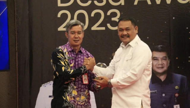 Kepala DPMPD Kabupaten Tangerang, Yayat Rohiman memberikan penghargaan kepada ketua apdesi kabupaten tangerang H. Maskota.dalam acara Desa Award 2023.Foto.(Istimewa)