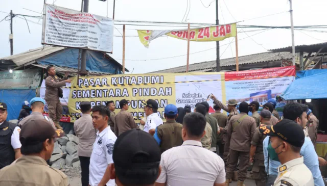 Satpol PP memasang spanduk yang bertuliskan pasar kuta bumi pindah sementara ke TPPS, yang terbentang di atas pagar, Foto. (Istimewa)