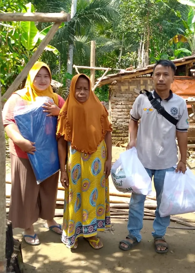 Azam Relawan Pejuang Baraya bersama Ibu Rati (65) saat mendampingi bantuan dari BPBD Lebak, pada Selasa (11/02/2025).